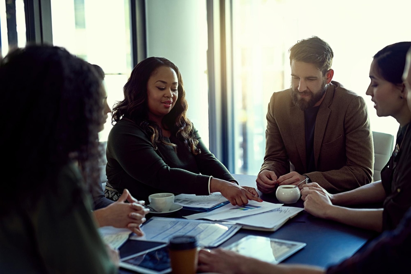 Business people reviewing paperwork in a meeting with a presentation
