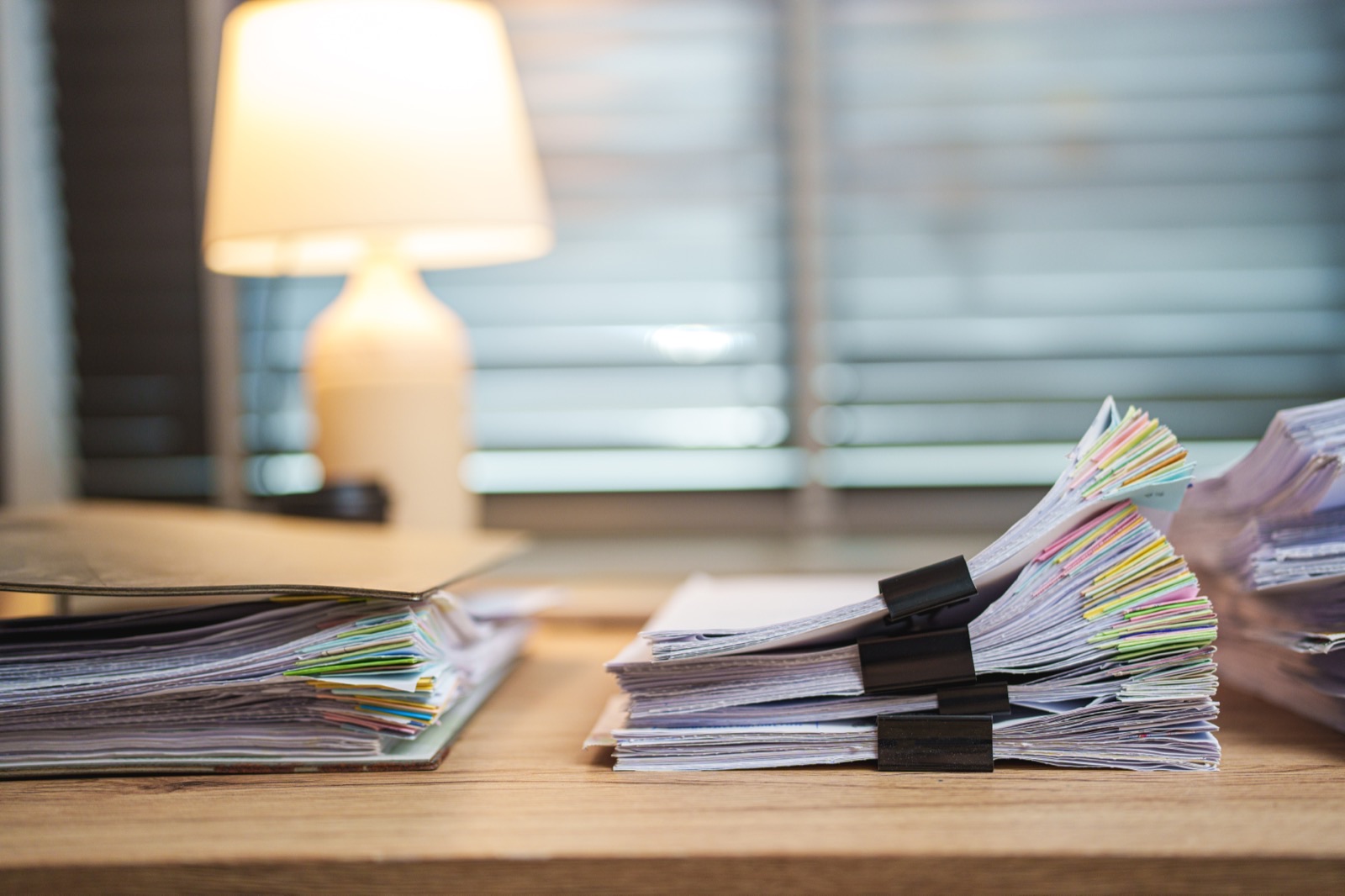 Stacks of white papers on an office desk