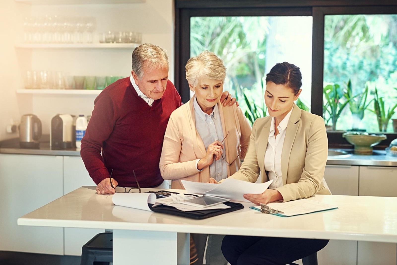 A senior couple going through financial paperwork with an accountant